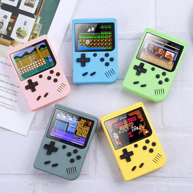 Five colorful handheld games consoles on a light surface with visible text and images.
